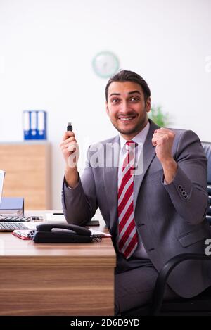 Männlicher Mitarbeiter, der Flash-Laufwerk in den Laptop einsteckt Stockfoto