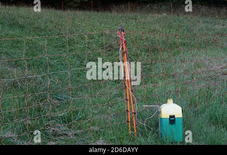 Elektrische Zäune mit einer Batterie auf einer Wiese angezeigt. Eine mobile Technologie, die Tiere in bestimmten Bereich hält und verhindern, dass sie zu entkommen. Stockfoto