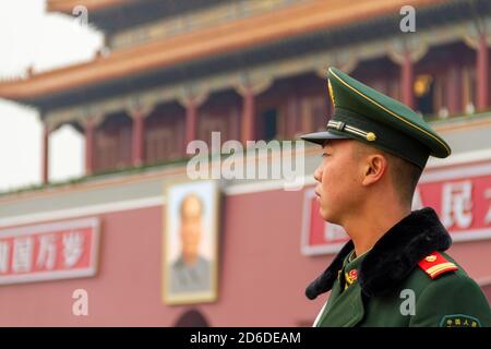 Peking, China - November 21 2019: Junger chinesischer Soldat bewacht das Tor des himmlischen Friedens. An den Seiten von Maos Porträt steht: "Lang lebe der Peop Stockfoto