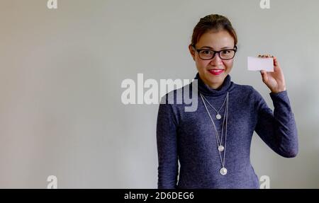 Schöne junge asiatische Frau lächelnd und zeigt leere Visitenkarte, auf weißem Hintergrund. Asiatisch chinesisch weiblich professionell während halten ein blank whit Stockfoto