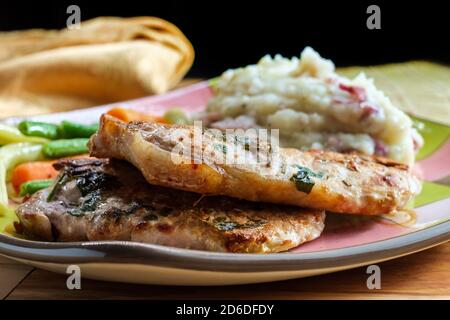 Salbei und Rosmarin BBQ Schweinekoteletts mit Haut - auf Kartoffelpüree und grünen Bohnen Stockfoto