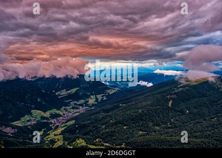 Luftaufnahme auf St. Ulrich, von der Seilbahn Seceda, dunkle Wolken beleuchtet von Sonnenuntergang Stockfoto