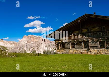 Ein hölzernes Berghaus unterhalb des Gipfels von Seceda, Secèda, Teil des Naturparks Puez-Geisler, Parco naturale Puez Geisler, Felswände in der Ferne Stockfoto