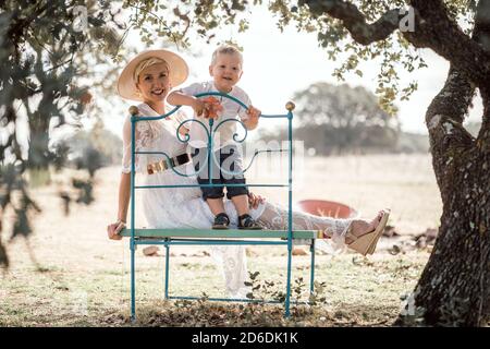 Schwangere Frau verbringt Zeit mit ihrem kleinen Sohn in der Natur Stockfoto