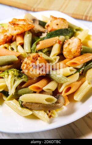 Garnelen Primavera mit Trikolore Penne in einer Weißweinsauce Stockfoto