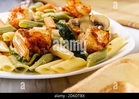 Garnelen Primavera mit Trikolore Penne in einer Weißweinsauce Stockfoto