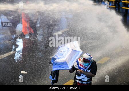 Bangkok, Thailand. Oktober 2020. Die Polizei benutzt Wasserwerfer, um während einer regierungsfeindlichen Kundgebung in Bangkok prodemokratische Demonstranten zu zerstreuen. Pro-demokratische Demonstranten nehmen an einer Kundgebung gegen die royalistische Elite und die vom Militär unterstützte Regierung Teil, die politische und monarchistische Reformen fordert. (Foto von Vichan Poti/Pacific Press) Quelle: Pacific Press Media Production Corp./Alamy Live News Stockfoto