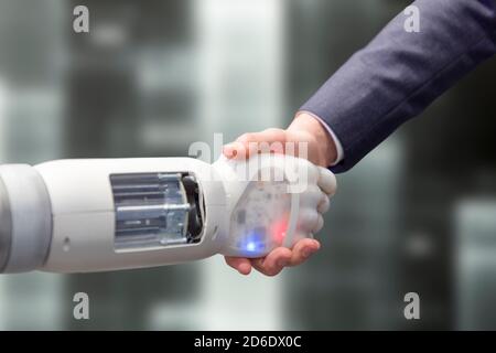 Roboter schüttelt die Hände mit einem Mann Stockfoto