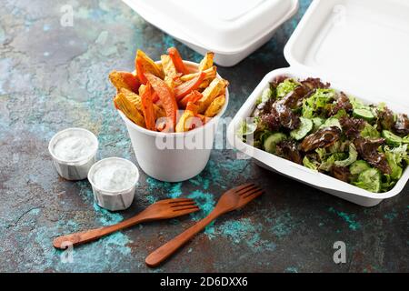 Geröstete Süßkartoffeln und Sellerie-Wurzel, Salat mit Gemüse und geräucherten Austern und Kokosjoghurt-Sauce mit Kräutern, Street Food in Papiergerichten. Paleo
