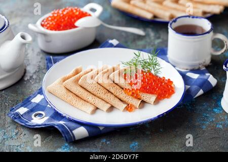 Traditionelle russische Pfannkuchen mit rotem Kaviar auf einem Teller, selektiver Fokus Stockfoto