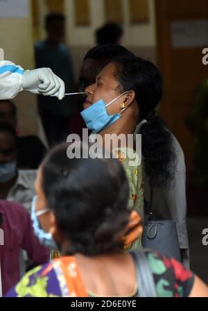 Guwahati, Assam, Indien. Oktober 2020. Ein Gesundheitsarbeiter nimmt nasalen Tausch von einer Frau, um COVID -19 Virus während Unlock 5 zu testen, während andere warten, bis sie an der Reihe COVID -19 in Guwahati Assam Indien am Freitag, 16. Oktober 2020 testen. Quelle: Dasarath Deka/ZUMA Wire/Alamy Live News Stockfoto