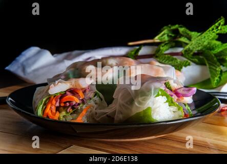 Frische Scheiben vietnamesischen Garnelen und Gemüse Frühlingsrollen mit Erdnuss Satay Dipping und Entensoße Stockfoto