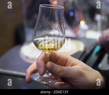 Hand hält ein Whisky Tasting Glas Stockfoto