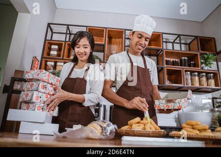 Junge Paare machen Backwaren Donuts in der Küche im Bäckerei Shop als Unternehmen Eigentümer Unternehmer Stockfoto