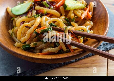 Gebratener Kimchi udon Nudel Bokkeum mit frischen kirby-Gurken-Karotten Und Gochujang Sauce Stockfoto