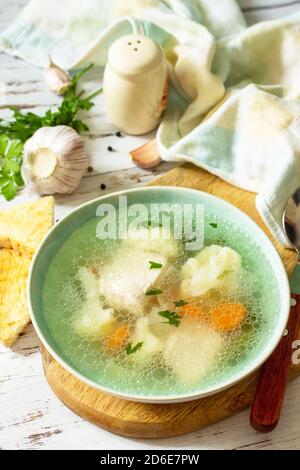 Gesunde Ernährung Konzept. Diät putensuppe mit Gemüse serviert Croutons auf einem weißen Holztisch. Stockfoto