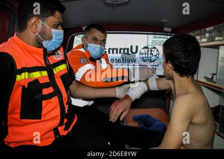 16. Oktober 2020: Gaza, Palästina. 16. Oktober 2020. Eine Rettungsmannschaft der palästinensischen Zivilverteidigung leistet Hilfe für einen 12-jährigen Jungen, der in seinem rechten Arm im Küstengebiet von al-Sudania im nördlichen Gazastreifen verletzt wurde. Der Junge wurde dann mit dem Krankenwagen in das indonesische Krankenhaus in Jabalia gebracht, um die entsprechende medizinische Behandlung zu erhalten.Kredit: Ahmad Hasaballah/IMAGESLIVE/ZUMA Wire/Alamy Live News Stockfoto