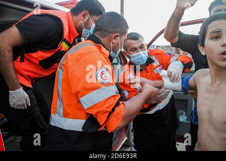 16. Oktober 2020: Gaza, Palästina. 16. Oktober 2020. Eine Rettungsmannschaft der palästinensischen Zivilverteidigung leistet Hilfe für einen 12-jährigen Jungen, der in seinem rechten Arm im Küstengebiet von al-Sudania im nördlichen Gazastreifen verletzt wurde. Der Junge wurde dann mit dem Krankenwagen in das indonesische Krankenhaus in Jabalia gebracht, um die entsprechende medizinische Behandlung zu erhalten.Kredit: Ahmad Hasaballah/IMAGESLIVE/ZUMA Wire/Alamy Live News Stockfoto