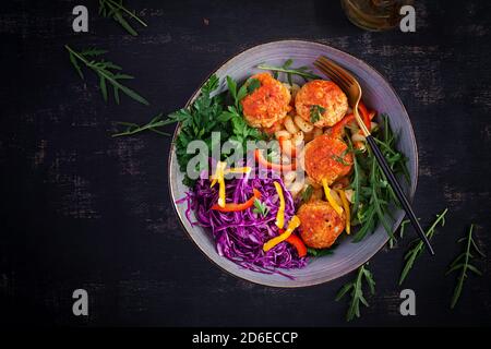 Italienische Pasta. Cavatappi mit Fleischbällchen und Salat auf dunklem Hintergrund. Abendessen. Draufsicht, Overhead. Slow Food Konzept Stockfoto