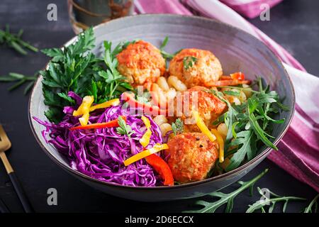 Italienische Pasta. Cavatappi mit Fleischbällchen und Salat auf dunklem Hintergrund. Abendessen. Slow Food Konzept Stockfoto