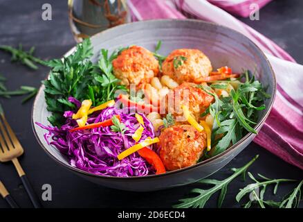 Italienische Pasta. Cavatappi mit Fleischbällchen und Salat auf dunklem Hintergrund. Abendessen. Slow Food Konzept Stockfoto