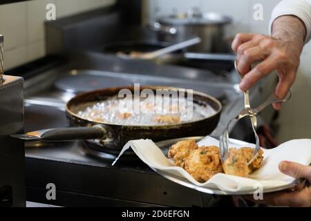 Kabeljau Fischfritter werden in der Küche gebraten Stockfoto