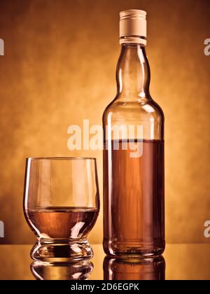 Flasche Whiskey mit einem gefüllten Glas Stockfoto