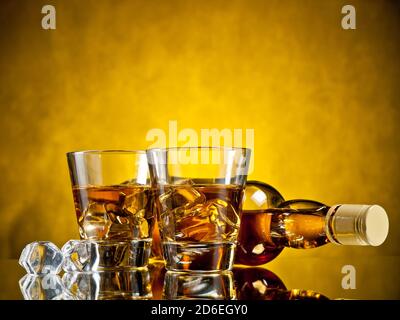 Flasche Whiskey und zwei Whiskeys auf den Felsen Stockfoto