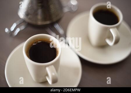 Schwarzer türkischer Kaffee in Elfenbein Kaffeetassen minimalistischen Stil Nahaufnahme Stockfoto