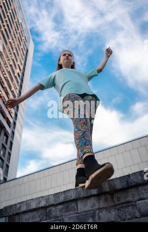 Blick von unten auf stilvolle Teenager in der Nähe Wolkenkratzer zu Fuß im Freien Stockfoto