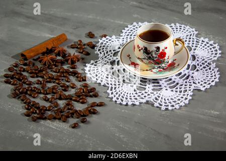 Eine Tasse Kaffee mit Kaffeebohnen und Zimt und Anis Stockfoto