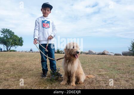 Deutschland, Mecklenburg-Vorpommern, Sassnitz, Junge steht mit Hund an der Strandpromenade Stockfoto