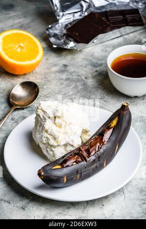 Gegrillte Banane mit dunkler Schokolade und Vanilleeis. Stockfoto