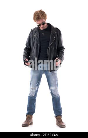 Selbstbewusst stilvolle Rocker Kauf Kleidung versucht auf schwarzem Leder Jacke sieht nach unten. Ganzkörper isoliert auf weißem Hintergrund. Stockfoto