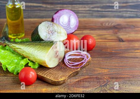 Geräucherter Makrele. Frisches Fischfilet mit kulinarischen Zutaten, Kräuter und Zitrone auf schwarzem Hintergrund, Seitenansicht. Speicherplatz kopieren. Stockfoto