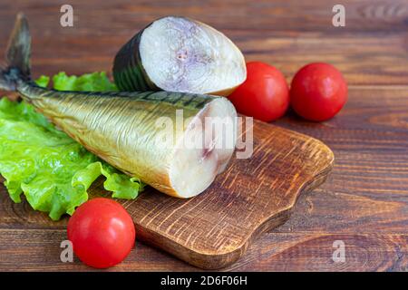 Geräucherter Makrele. Frisches Fischfilet mit kulinarischen Zutaten, Kräuter und Zitrone auf schwarzem Hintergrund, Seitenansicht. Speicherplatz kopieren. Stockfoto