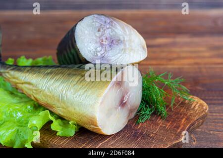 Geräucherter Makrele. Frisches Fischfilet mit kulinarischen Zutaten, Kräuter und Zitrone auf schwarzem Hintergrund, Seitenansicht. Speicherplatz kopieren. Stockfoto