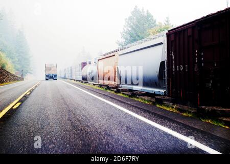 LKW auf dem Highway neben dem Güterzug, Wildfire Smoke Obstructing Distance, Oregon, USA Stockfoto