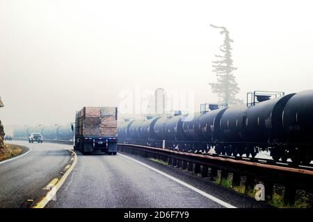 Waldbrand Rauch und Straßenverkehr neben Eisenbahnwaggons Transport Öl Stockfoto