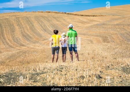 Familie, Vater, Mutter und Tochter von hinten Blick auf die Hügel im Val d'Orcia, Castiglione d'Orcia, Provinz Siena, Toskana, Italien Stockfoto