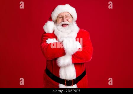 Foto von verrückten funky weihnachtsmann mit großen Bauch Kreuz Hände x-Mas Magie Party tragen rot Kostüm schwarz Gürtel Kopfbedeckung Isoliert über hellen Glanz Farbe Stockfoto