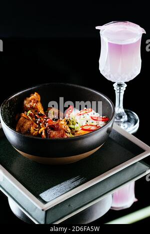 Asiatische Chicken Wings mit Reis auf schwarzem Hintergrund Stockfoto