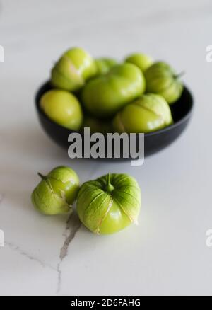 Schale mit frischen grünen Tomatillo-Früchten auf einer weißen Quarztheke. Stockfoto