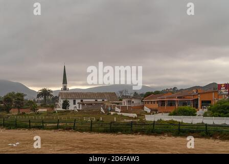 Coquimbo, Chile - 7. Dezember 2008: Am frühen Morgen trübe braune Wolkenlandschaft. Weiße Capilla San Gabriel Kapelle mit Turm und roten Häusern in der Nähe entlang c Stockfoto