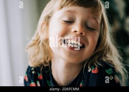 Junges Mädchen mit einem wackeligen Zahn lächelnd zeigt ihre Zähne Stockfoto