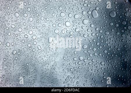 Regentropfen auf einer glatten Oberfläche Stockfoto