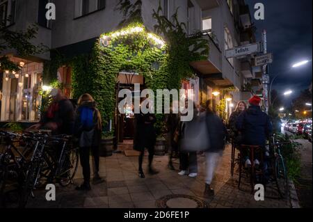 Berlin, Deutschland. Oktober 2020. Die Leute kommen aus einer Bar im Stadtteil Neukölln, die an der Ausgangssperre schließt. Neukölln ist derzeit der Corona-Hotspot mit den meisten Neuinfektionen innerhalb von sieben Tagen bundesweit. Quelle: Christophe Gateau/dpa/Alamy Live News Stockfoto