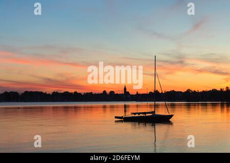 Segelboot bei Sonnenuntergang auf dem Chiemsee, Riemsting, Oberbayern, Deutschland Stockfoto