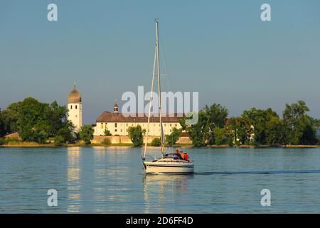 Segelboot auf dem Chiemsee vor der Fraueninsel mit Kloster Frauenwöth bei Sonnenuntergang, Oberbayern, Deutschland Stockfoto