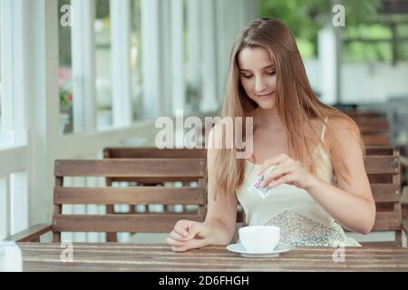 Frau gießen Zucker Kaffee Tasse. Gemischten rennen Kaukasischen asiatische Modell Stockfoto